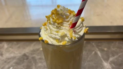 Close Up Of Mango Smoothie With Red White Striped Straw Stock Footage 332662388