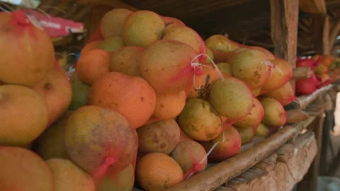 Close-up of mangoes in fruit nets on makeshift stall. Slow motion. 库存影片 310673303