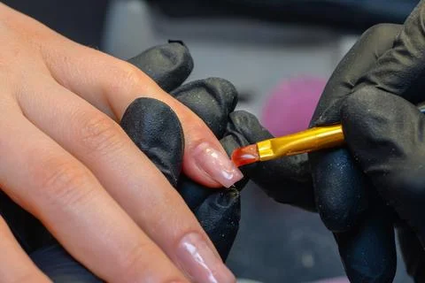 Close-up manicure process, female hands painting nails Stock Photos