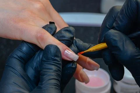 Close-up manicure process, female hands painting nails Stock Photos