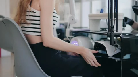 Close-up manicure session, UV lamp dries fresh nail polish quickly Stock Footage 313916897