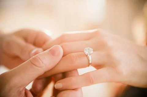 Close up of man's and woman's hands with engagement ring Stock Photos