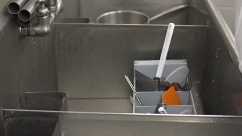 Close-up of man’s arms washing baking utensils in stainless kitchen sink Stock Footage 317174517