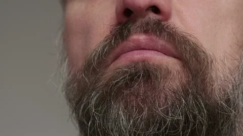 Close up of man's bearded face. Man puts on respiratory mask to prevent Stock Footage 134960844