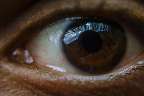 Close up of a man's brown eye with reflection of clouds in te iris Stock Photos