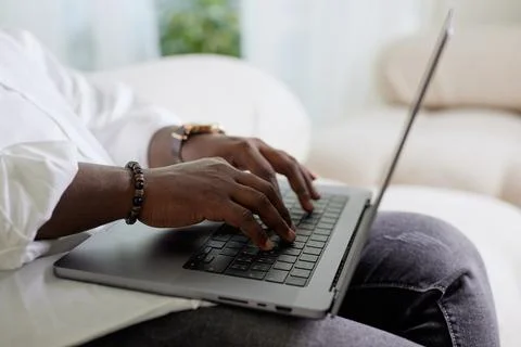 Close-up of a man's dark-skinned hand working on a laptop, American African.. Stock Photos