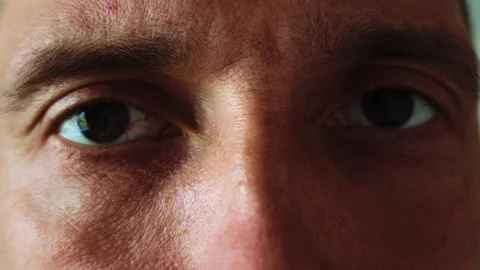 Close-up of a man's eyes and forehead showing skin texture and slow blinking Stock Footage 345521274