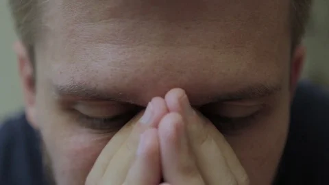 Close up of man's eyes and hands covering nose. Video stock 77413635