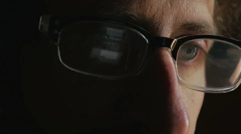 Close up of a mans eyes scrolling through a cell phone reflected in his glasses Stock Footage 65908960