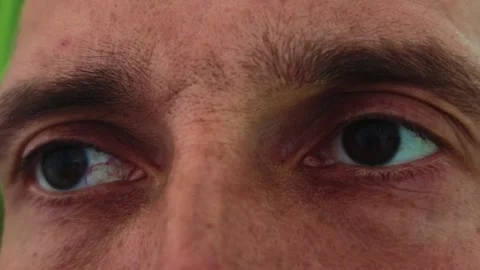 Close-up of man's eyes shifting left with visible blood vessels and freckles Stock Footage 345521312