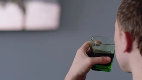 Close-up of a man's face drinking a drink and watching TV Stock Footage 155558850