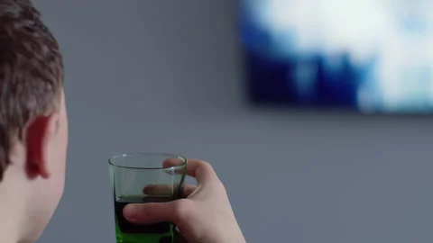 Close up of a man's face, drinks a drink in the evening and watches TV, side Stock Footage 155960439