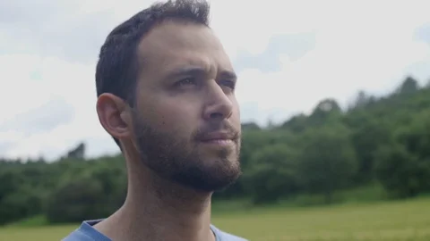 Close Up of man's face looking serious. Looking around. Surrounded by nature Stock Footage 107263113