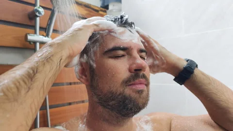 Close up of a mans face massaging his head in the shower. Video stock 318474922