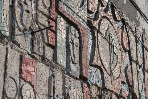 Close-up of a man's face on an old Soviet mosaic panel. Stock Photos