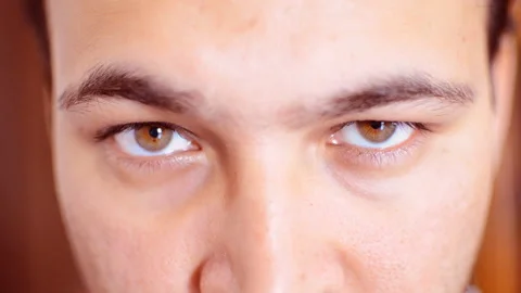Close up of  man's face opening eyes with angry look Stock Footage 142210245