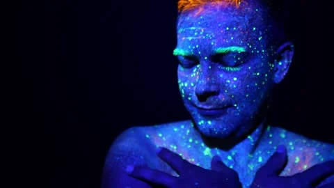 Close-up of a mans face painted with fluorescent paints. Stock Footage 313939150