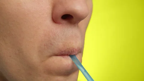 Close-up of a man's face with a plastic straw, yellow background Stock Footage 151267943