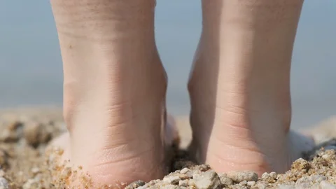 Close-up of a man's feet on the beach, going into the water. Back view Stock Footage 128108788