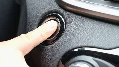 A close-up of a man's finger pressing the start button in a car. Stock Footage 341554858