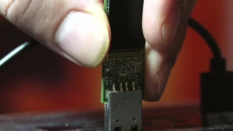A close-up man's fingers inserting a glowing, disassembled flash drive Video stock 346882032
