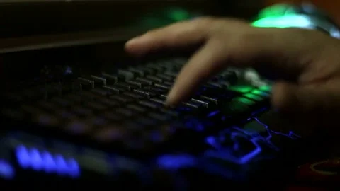 A close-up of a man's fingers typing on a glowing keyboard 库存影片 333706702