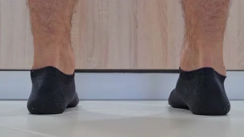 A close-up of a man's foot against the background of a kitchen wooden cabinet Stock Footage 202143301