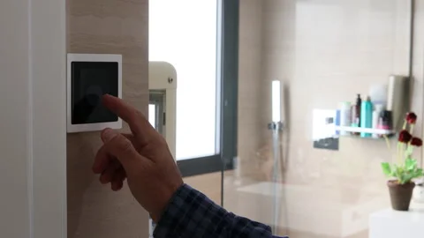 Close-up of man's hand adjusting the temperature on a home automation screen Video stock 224884096