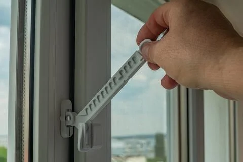 Close-up of a man's hand adjusting a window opening limiter. Window stop ad.. Stock Photos