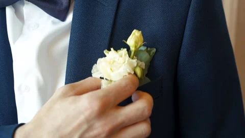 Close-up of man's hand adjusts a bouquet of flowers in his blue jacket pocket Stockbeeldmateriaal 285346462