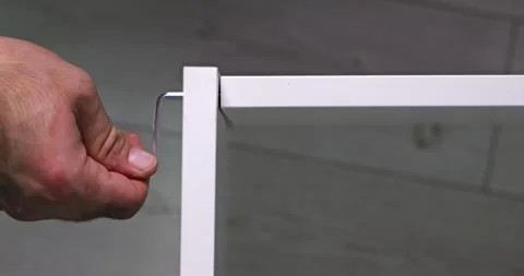 Close up. Man's hand is assembling new wooden bed in the living room. He is Stock Footage 265807228