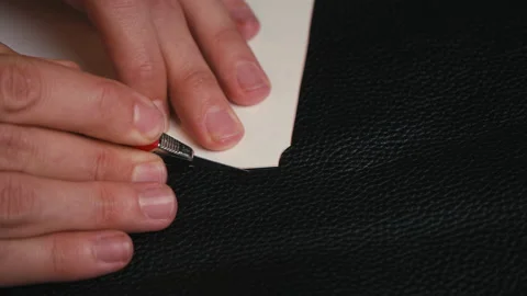 Close up man's hand cutting out of leather with a special knife of the sizes Stock Footage 138260412
