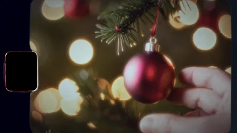 Close-up of man's hand decorating Christmas tree with balls shot on 8mm film Stock Footage 291276238