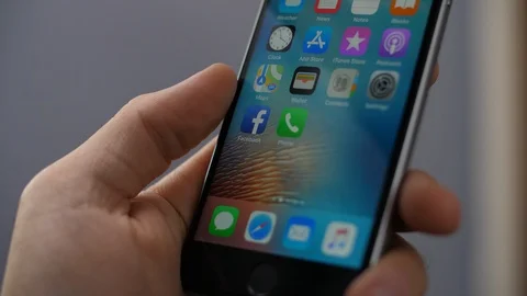 Close up on a man's hand deleting the Facebook app Stock Footage 96186825