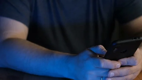 Close-up of a man's hand dialing number on a cell phone in neon light. 스톡 동영상 128095018