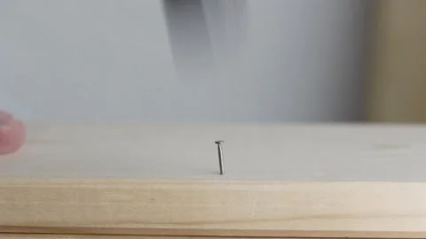 Close-up of a man's hand driving a nail into a wooden board. Video stock 344124022