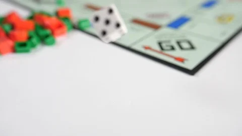 Close up of a mans hand dropping two dice onto a board game of red and green  Stock Footage 89186751