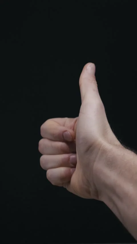 Close Up Mans Hand Giving Thumbs Up On Dark Background Stock Footage 329135022