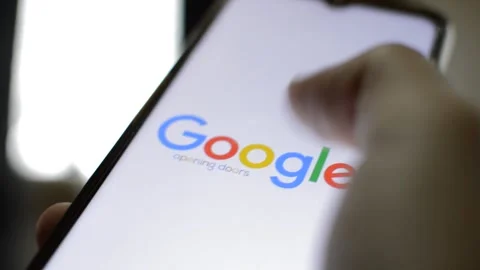 Close-up man's hand hold iphone with google app on the display. Video stock 229114138