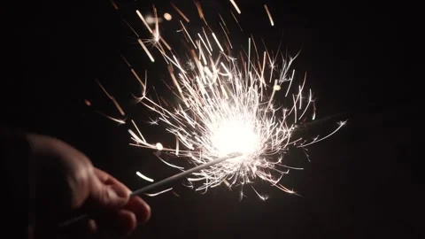 Close-up of a man's hand holding a burning sparkler in the dark. Stock-Footage 248144427