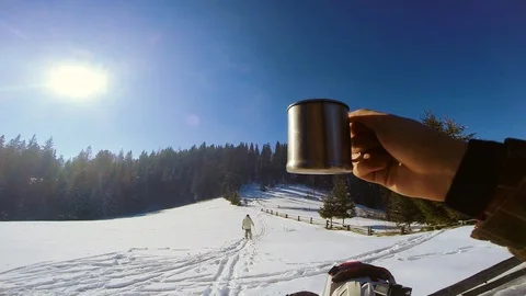 Close up of a man's hand holding a cup in the background of people skiers in the 스톡 동영상 105269631