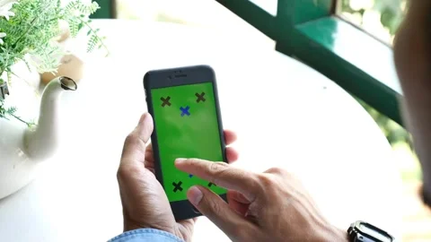 Close up of a Mans Hand Holding Green Mock up Screen Smartphone with tracking Video stock 336585747