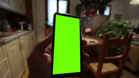 Close up of a man's hand holding a mobile telephone with a vertical green screen Stock Footage 129711400