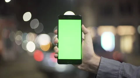 Close up of a man’s hand holding a mobile telephone with a vertical green Stock Footage 134383548