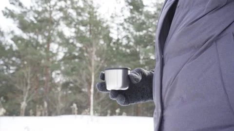 Close-up of a man's hand holding a mug of hot drink from a thermos while Stock Footage 201146726