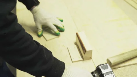 Close-up of a man's hand holding a pneumatic stapler and attaching wood pieces Stock Footage 225140428