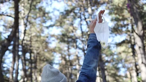 Close up man’s hand holding protective mask over green forest view Stock Footage 241017573