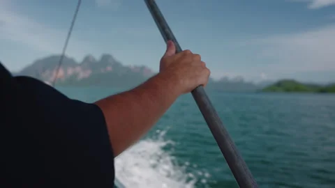 Close-up of Mans Hand Holding Rail on Moving Longtail Boat, Traveling Across 库存影片 334643454