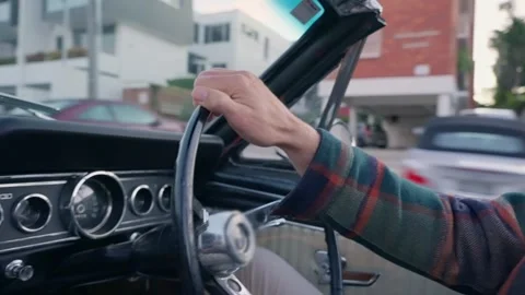 Close up on man's hand holding right side steering wheel of vintage vehicle Stock Footage 288316582
