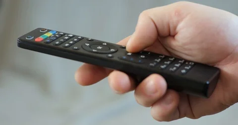 Close up mans hand holding TV remote control and changing TV channels Stock Footage 104872087